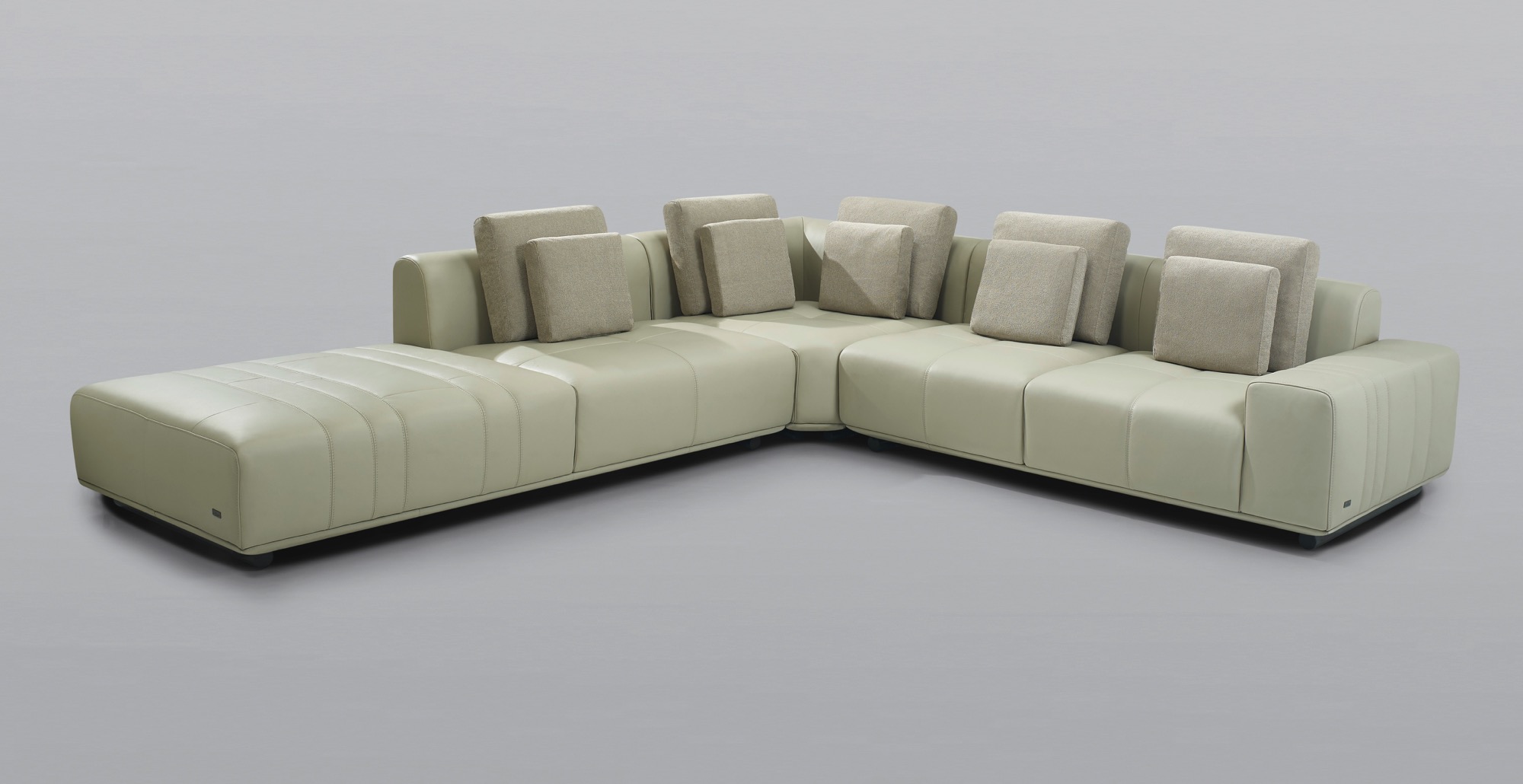 A picture of a tan leather sectional sofa on a grey background